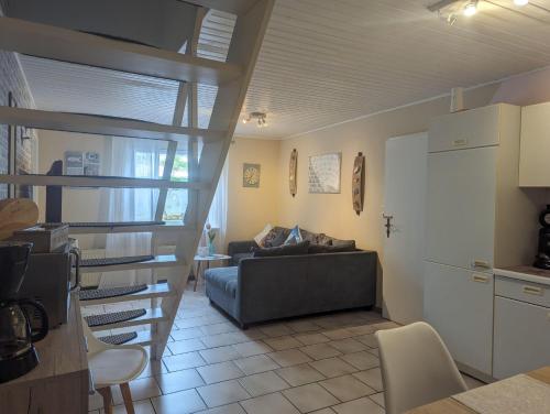 Una sala de estar con un sofá y una cocina. en Ferienwohnungen-im-Koog, en Wesselburenerkoog