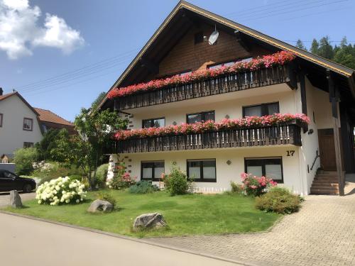 a house with flowers on the side of it at Haus Hubertus in Enzklösterle