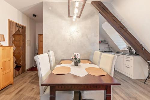 a dining room with a wooden table and white chairs at Gemütliches Appartament in Aldingen