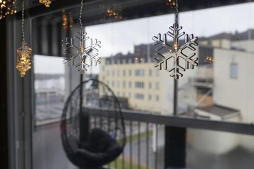 a bird cage with snowflake decorations hanging from a window at Bright Elegant - Feel Lapland with light & harmony in Rovaniemi