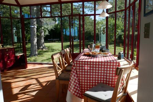une table avec un chiffon de table rouge et blanc dans l'établissement Villa Ty Marie Ile aux Moines sur la plage vue mer à 180 dégrés, à l'Île-aux-Moines