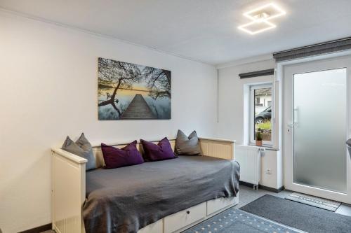 a bedroom with a bed with purple pillows at Fewo Am Wiesbachtal in Wehrheim