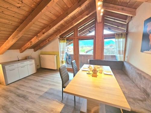 グラッサウにあるFerienwohnung Weitblick Grassauの木製のテーブルと椅子のあるキッチンとダイニングルーム