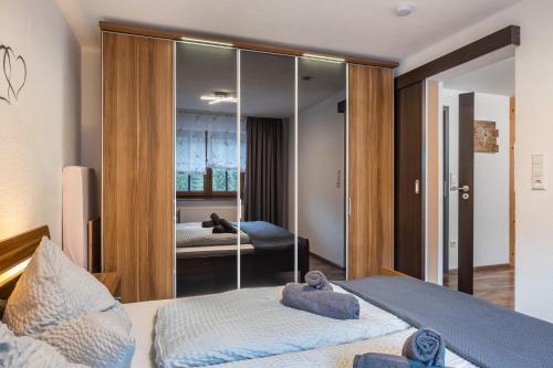 Un dormitorio con dos camas y un espejo. en Appart Herzglück, en Bad Rippoldsau-Schapbach