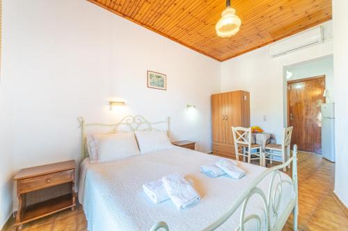 a bedroom with a white bed with two towels on it at Korina Studios in Paleokastritsa