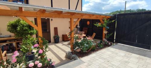 un patio con pérgola de madera y algunas flores en Ferienwohnung Am Dächsberg, en Plauen
