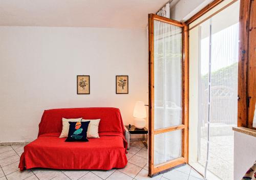 a red bed in a room with a window at Bilo Le Lecce 15b in Capoliveri