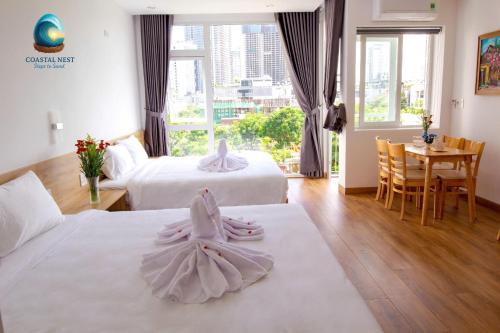 een hotelkamer met twee bedden en een tafel bij Coastal Nest - Steps to Sand in Da Nang