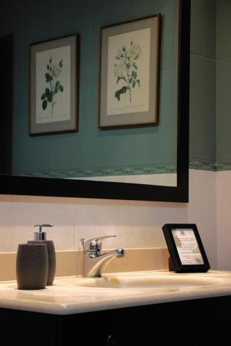 a bathroom sink with a mirror and a tablet on it at El Tercer Piso in Puente la Reina
