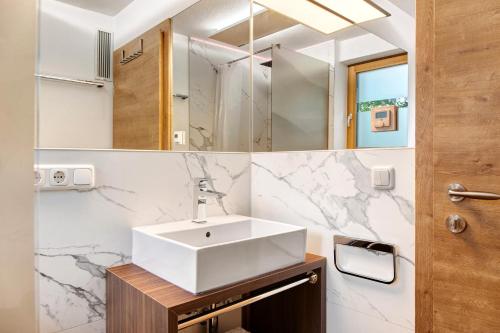 a bathroom with a sink and a mirror at Zugspitzstudio Apartment in Ehrwald