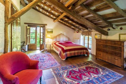 a bedroom with a bed and a chair in a room at Maison De Charme Avec Jacuzzi in Arcangues