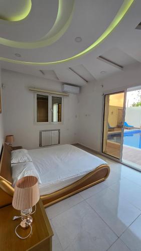 ein Schlafzimmer mit einem Bett und einem Tisch mit einer Lampe in der Unterkunft dar saoussen in Triffa