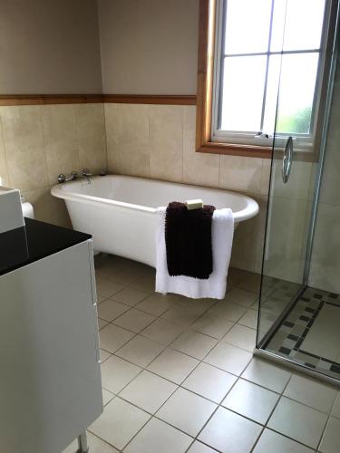 a white bath tub in a bathroom with a window at Cable Station Accommodation in Stanley