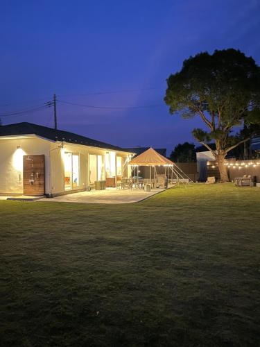 a building with a tent in a field at night at ダブルレインボー一宮 in Ichinomiya