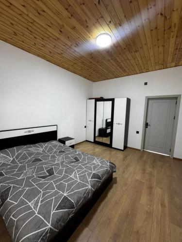 a bedroom with a large bed and a wooden ceiling at Barn House Guba in Qǝçrǝş