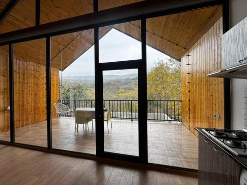 a kitchen with a large glass window and a table at Barn House Guba in Qǝçrǝş