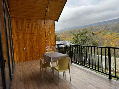 a table and chairs on a balcony with a view at Barn House Guba in Qǝçrǝş