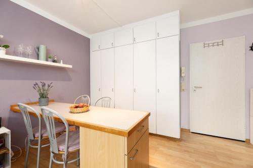 a kitchen with white cabinets and a table and chairs at Panorama Schönberg 02 in Schönberg