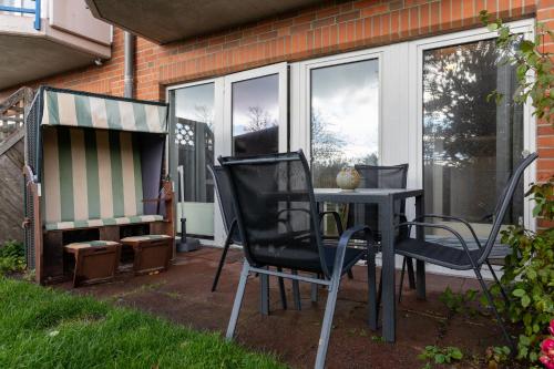 a patio with two chairs and a table in the yard at Panorama Schönberg 02 in Schönberg