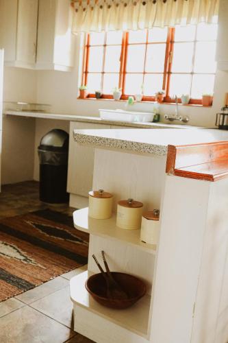 a kitchen with a wooden bowl on a shelf at Cicada Cottage Peaceful Drakensberg Retreat in Underberg