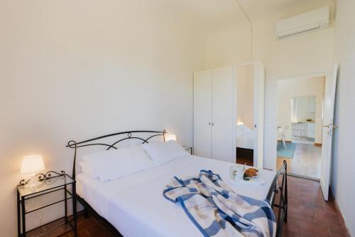 Una cama blanca con una manta azul y blanca. en San Salvi Cozy Apartment, en Florencia