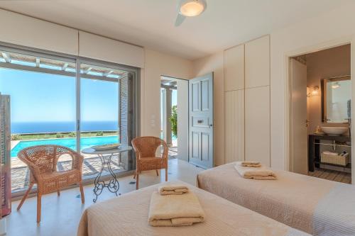 a bedroom with two beds and a view of the ocean at Villa Oliva - Majestic Views in Andros