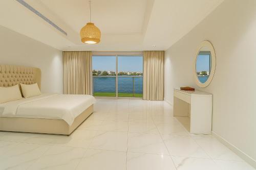 a bedroom with a bed and a large window at درة العروس فيلا نجمة البحر in Durat Alarous