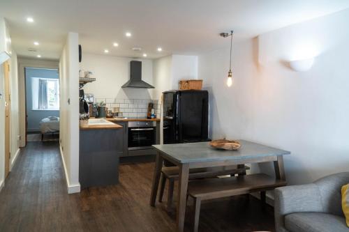 a living room with a table and a kitchen at Mor Ki -A perfectly situated modern flat in Looe in Looe