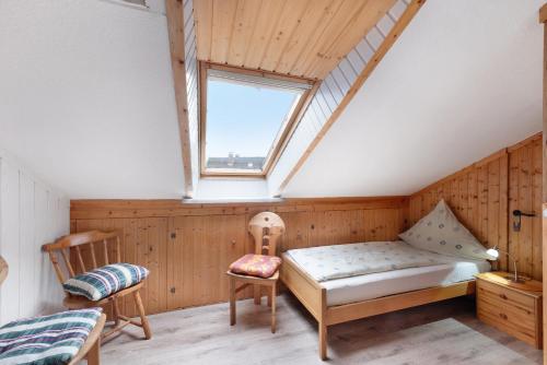 a attic room with a bed and a window at Landferien Schütt in Neuenkirchen