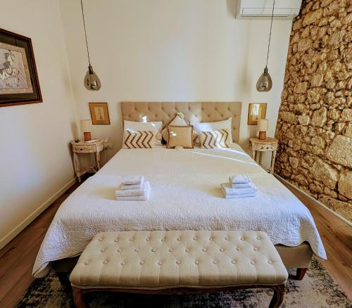 ein Schlafzimmer mit einem großen Bett mit einer Steinwand in der Unterkunft La Maison du Clocher in Saint-Émilion