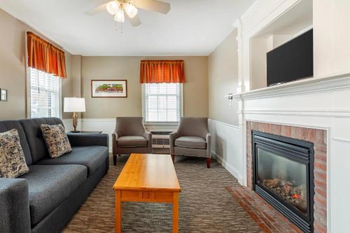 a living room with a couch and a fireplace at Essex Street Inn & Suites, an Ascend Collection Hotel in Newburyport