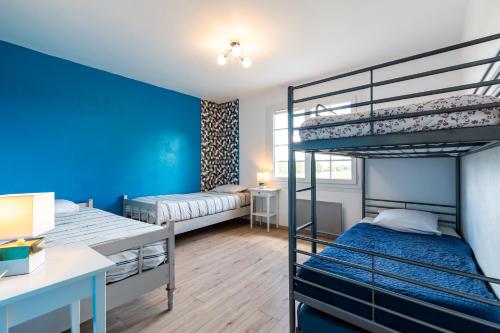 1 Schlafzimmer mit 2 Etagenbetten und einer blauen Wand in der Unterkunft Maison Cœur Des Vignes in Les Salles-de-Castillon