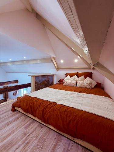 a bedroom with a large bed in a attic at La Mezzanine - Chambre avec Spa in Bellaing