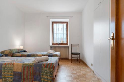 une chambre avec deux lits, une fenêtre et une chaise dans l'établissement Casa Del Sole, Relax E Natura, à Romeno