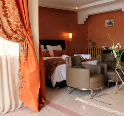 a hotel room with a bed and two chairs at Dar Souran in Tangier