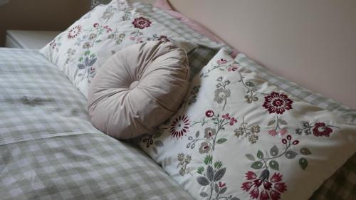 a pillow sitting next to a pillow with flowers on it at The Swallows Nest, Dog-Friendly Retreat with Garden in Marton