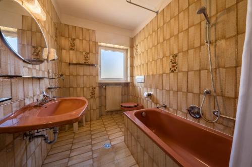 a bathroom with a red tub and a sink at Residence Kronstein - Fewo 5 in Tesimo