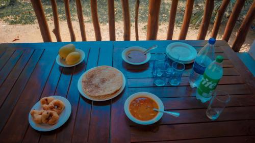 Una mesa con comida y bebidas sobre una mesa de madera. en Diamond Mount Villa, en Dambulla