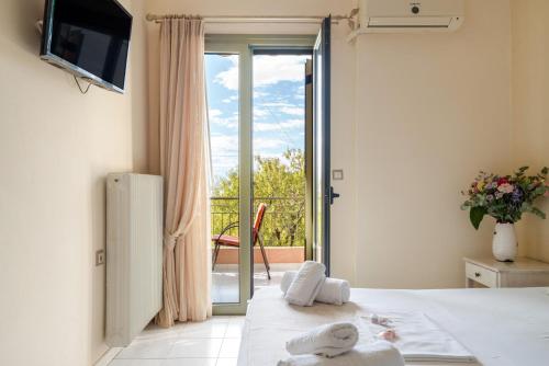 a bedroom with a bed and a sliding glass door at Nontas Home 23 in Kalamitsi
