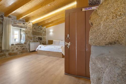 ein Schlafzimmer mit einem Bett in einem Steingebäude in der Unterkunft Country House - Casa Da Marquinhas in Lama de Ouriço