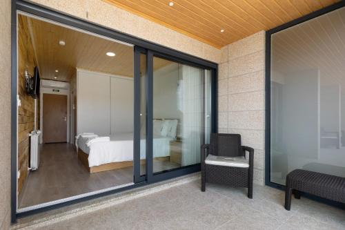 ein Schlafzimmer mit einem Bett und einem Stuhl in einem Zimmer in der Unterkunft Country House - Casa Da Marquinhas in Lama de Ouriço