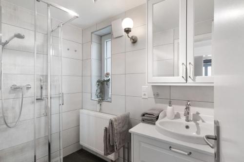 a white bathroom with a sink and a shower at Schwarzwaldtani - Städtle 2 in Bühl