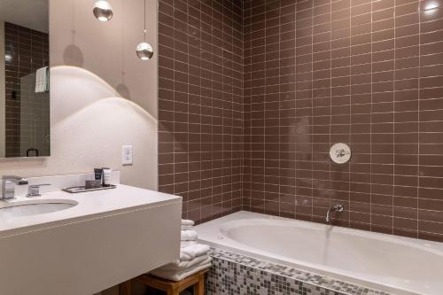 un baño con lavabo y bañera en The Chandler Inn Bethlehem - Littleton, an Ascend Collection Hotel, en Bethlehem