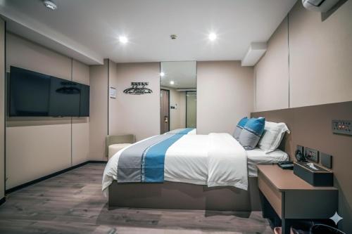 a bedroom with a bed and a desk and a tv at Ha Fa Villa in Hong Kong