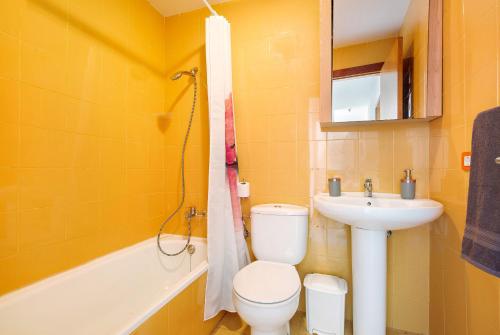 Un baño amarillo con inodoro y lavabo. en My Favorite Home, en Caleta de Fuste