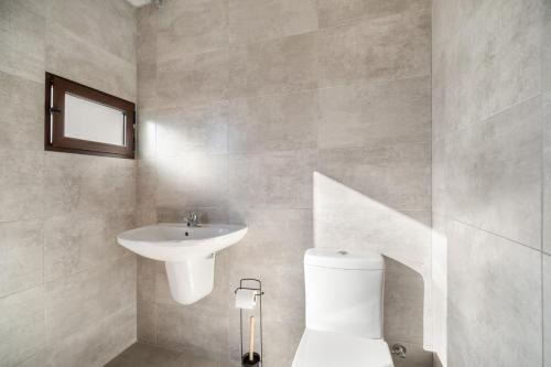 a bathroom with a toilet and a sink at Casa Rural La Ferrera Chiclana in Chiclana de la Frontera