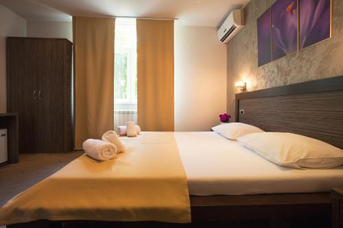 een slaapkamer met een groot bed en handdoeken bij Villa Mystique in Belgrado