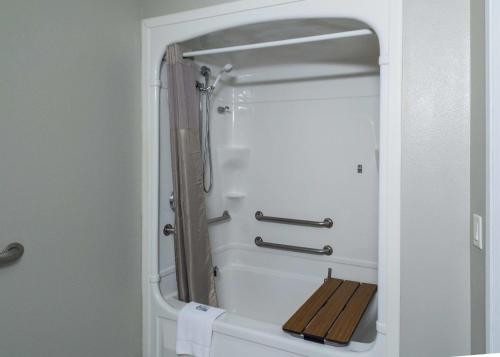 bagno con doccia e panca in legno di Studio Z, an Ascend Collection Hotel a Saint Robert