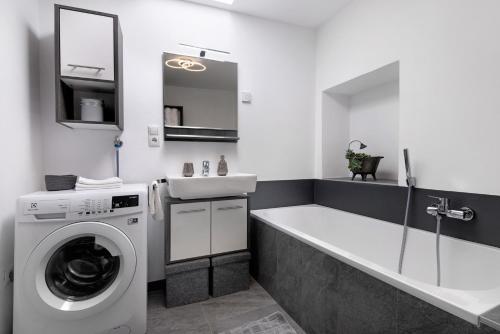 a bathroom with a washing machine and a sink at Ferienwohnung Garboshof in Lasa
