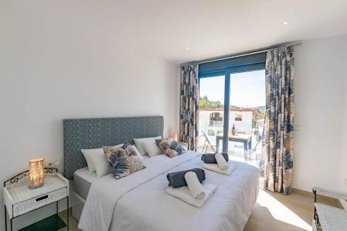 a bedroom with two beds and a large window at Luxury apartment in Cómpeta